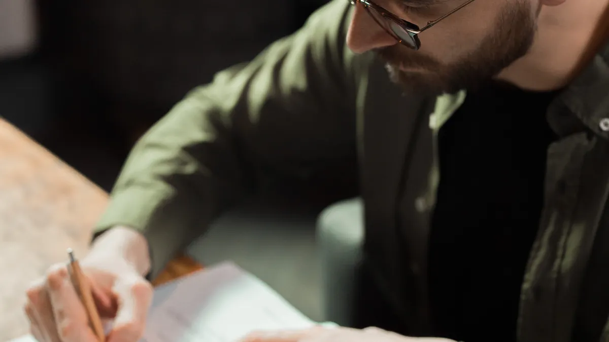 Best article outlining tools for writers — Man in Green Long Sleeve Shirt Writing on a Paper