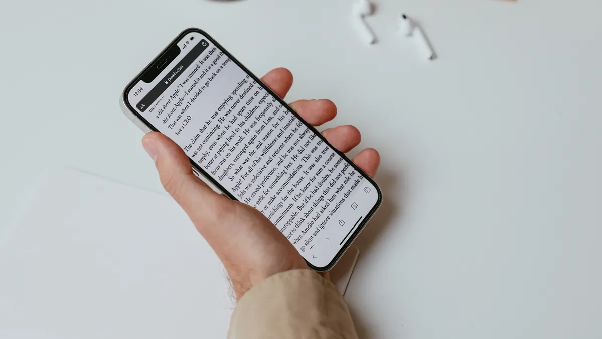 Best article writing software for long-form content — A Person Writing While Holding a Smartphone