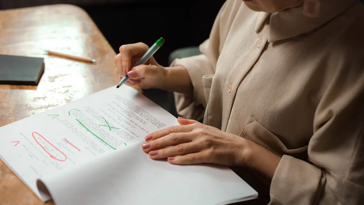 person editing a printed article with pen