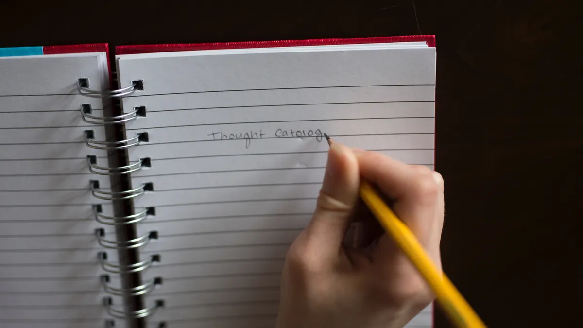 How to edit and refine drafts in article writing software — Person Writing on White Lined Paper