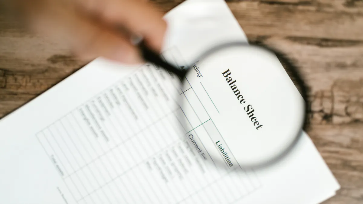 magnifying glass over a balance sheet document